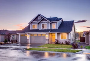 Two-story home with a shingle roof at sunset