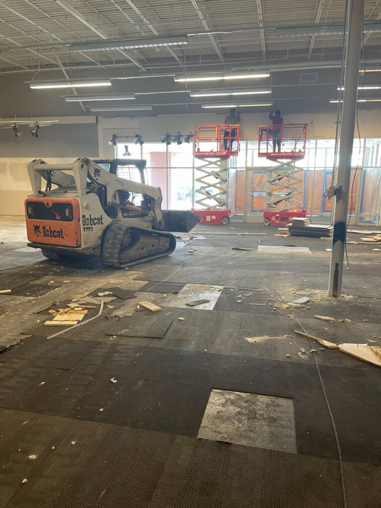 Commercial demolition in Mobile, AL: skid steer and lifts working the open floor