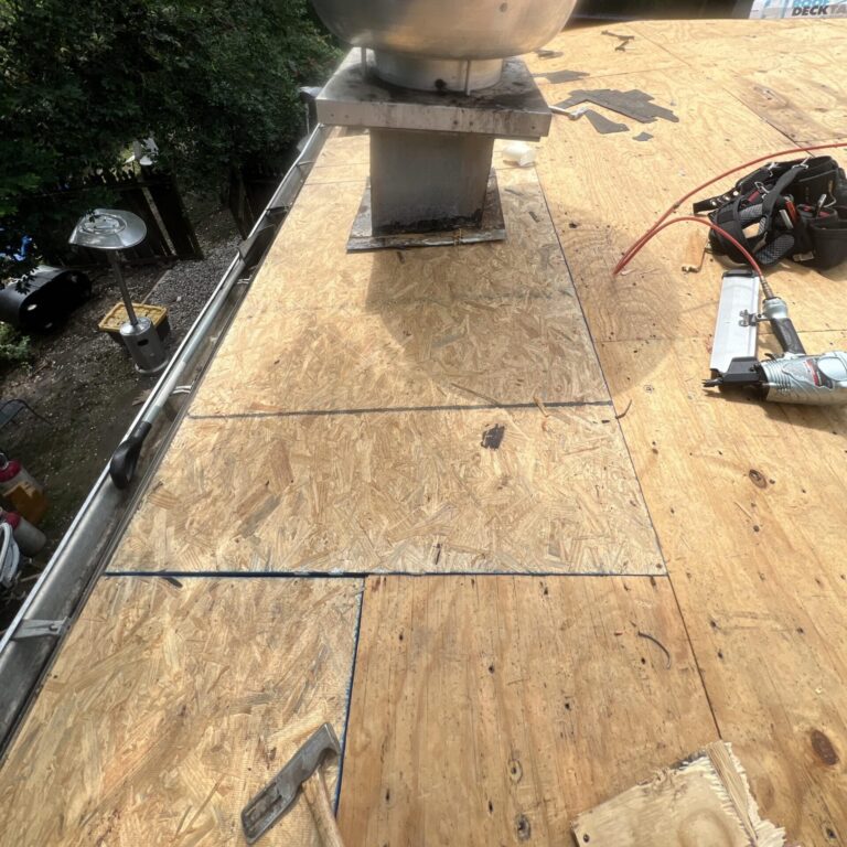 Roof replacement in Mobile, AL: new decking around the exhaust vent on the low-slope section
