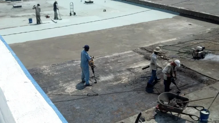 Crew tearing off the old roofing down to the concrete deck