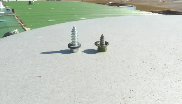 Rusted original roof fastener next to a new replacement fastener