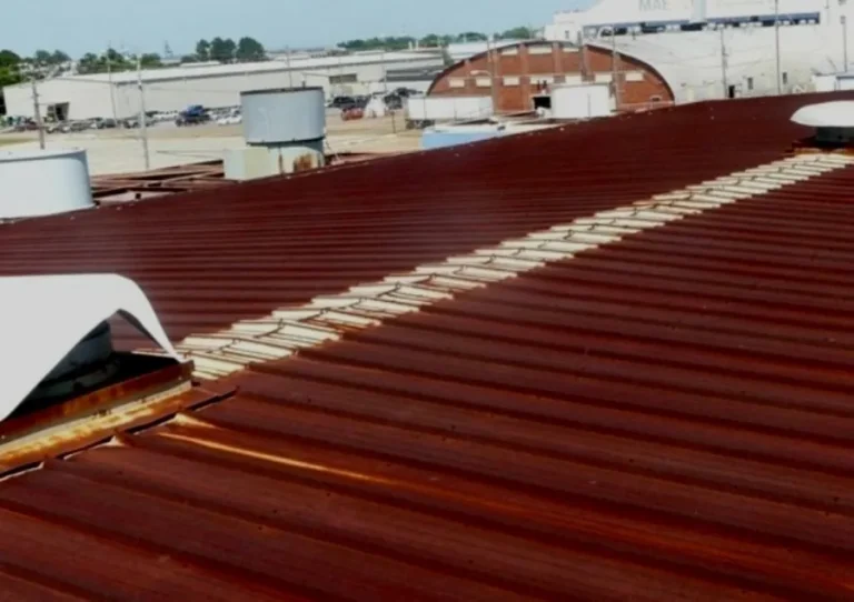Commercial metal roof with heavy surface rust before restoration